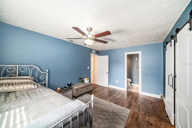 a bedroom with a bed and a ceiling fan