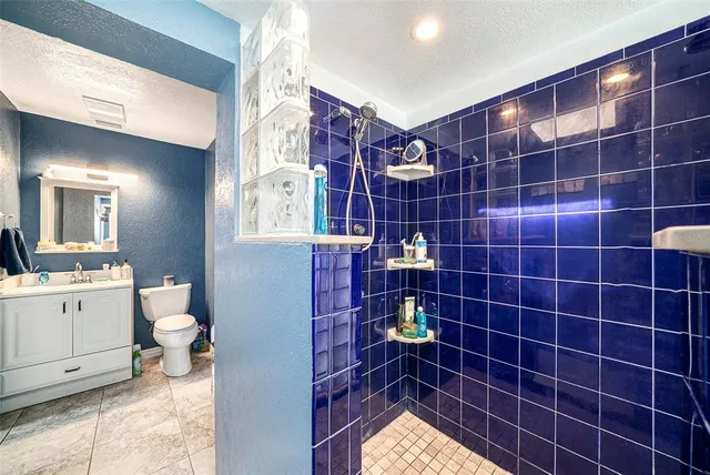 a bathroom with a toilet a sink a mirror and shower