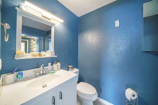 a bathroom with a toilet a sink and mirror