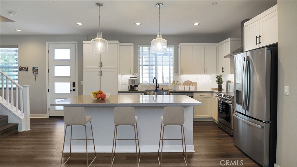 2180 Pearl Walk Gardena, CA 90249 - Photo 4 of 23 a kitchen with stainless steel appliances granite countertop a refrigerator a sink dishwasher a stove and white cabinets with wooden floor