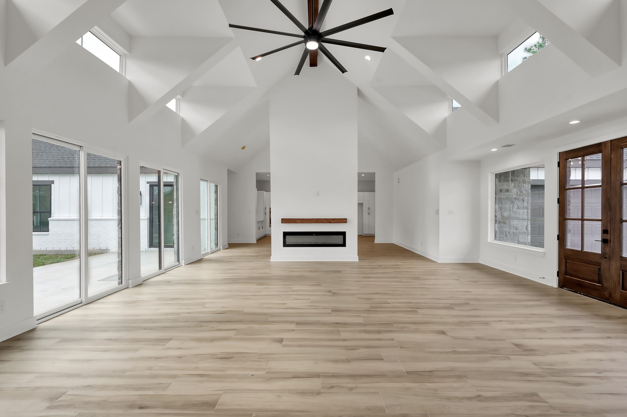 14742 Turquoise Trail Willis, TX 77378 - Photo 9 of 48 The living space features a sleek double-sided electric fireplace and walls of glass overlooking the backyard, blending indoor and outdoor living beautifully.