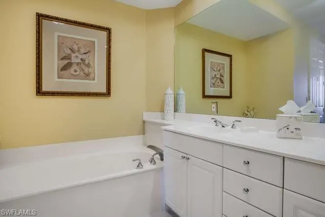 a bathroom with a tub sink and mirror