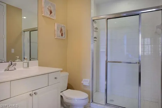 a bathroom with a sink toilet vanity and shower