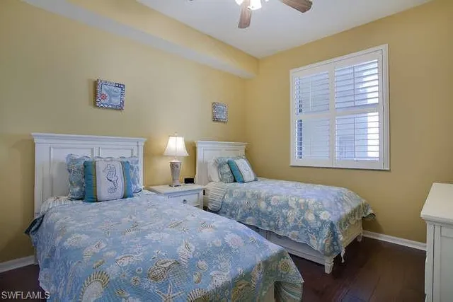 a bedroom with two beds and a lamp