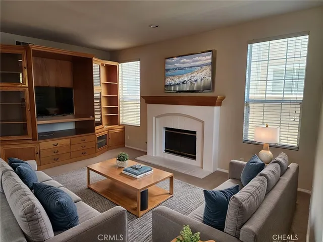 a living room with furniture a flat screen tv and a fireplace