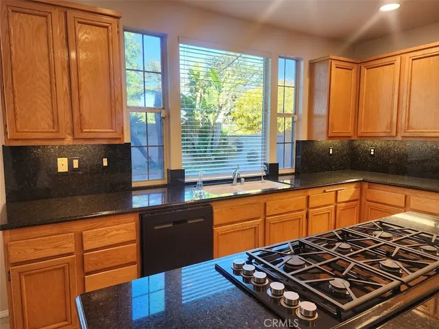 a kitchen with stainless steel appliances granite countertop a stove a sink and a granite counter tops