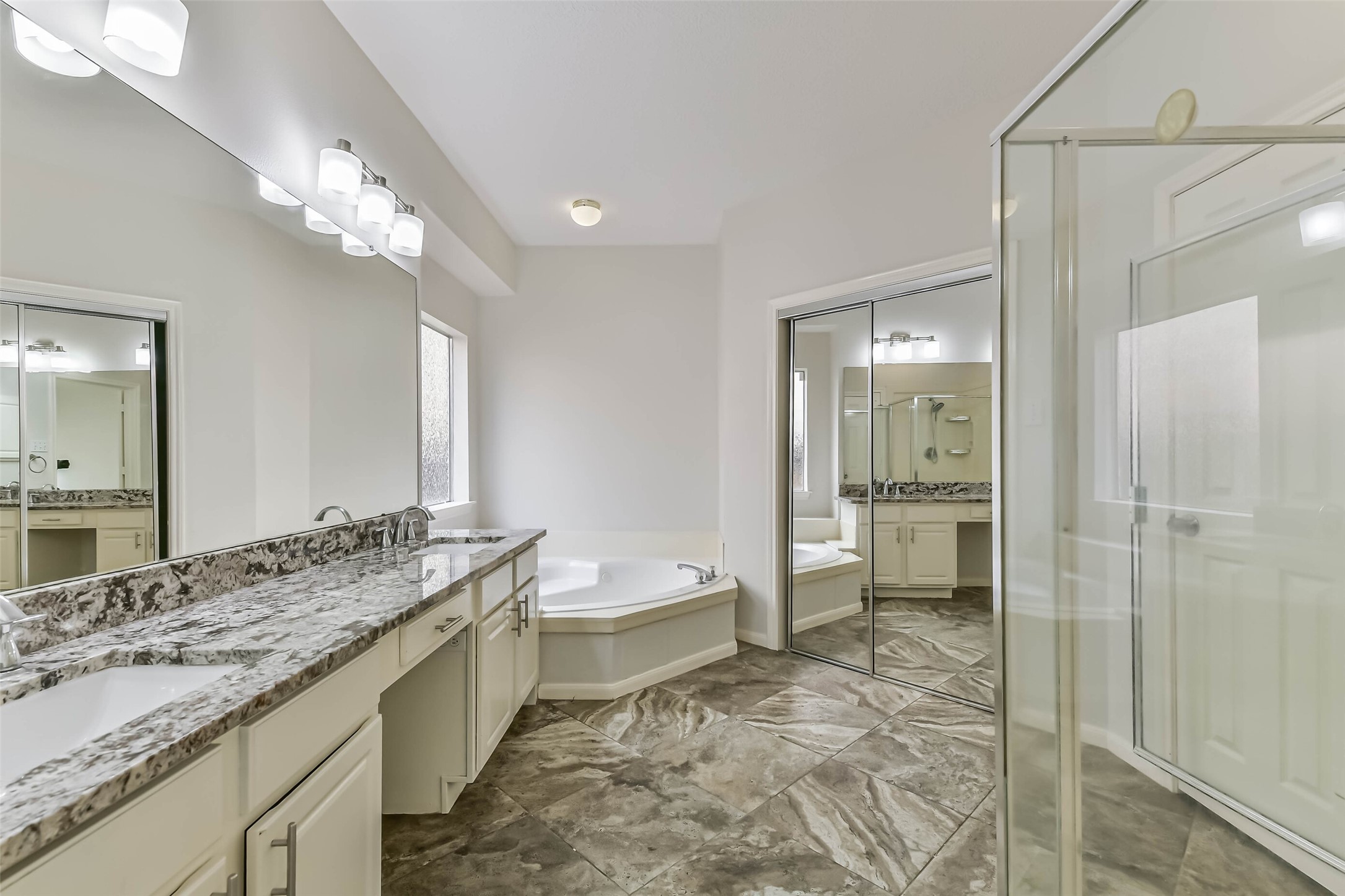 6338 Maple Spring Place Humble, TX 77346 - Photo 29 of 50 Choose a quick shower before heading out or a leisurely soak when the day is done. Separate bathing spaces, generous vanity storage and a large mirror make this private bath a practical place to start and finish your day.