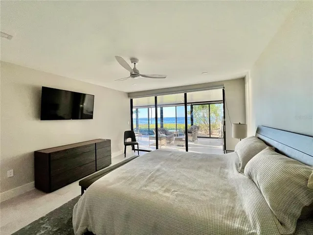 a spacious bedroom with a bed and a flat screen tv