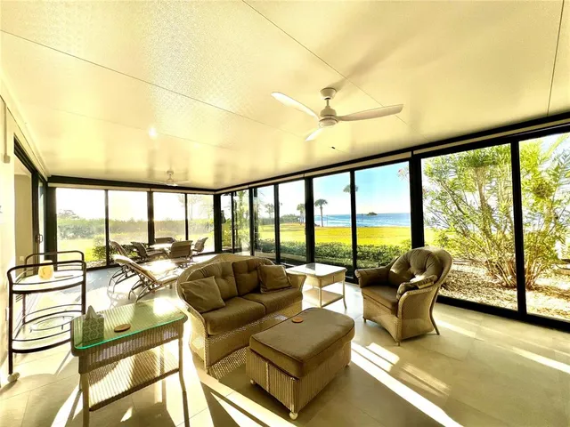 a living room with furniture and floor to ceiling windows