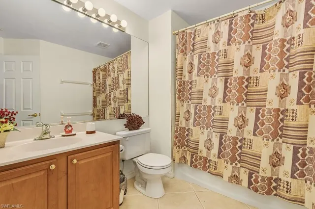 a bathroom with a sink a toilet and shower curtain