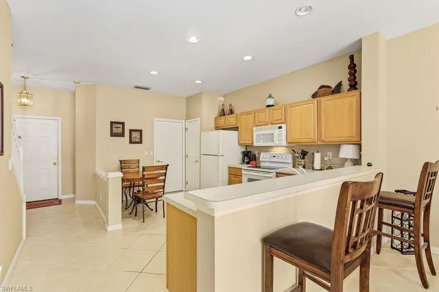 a kitchen with a table chairs refrigerator and cabinets