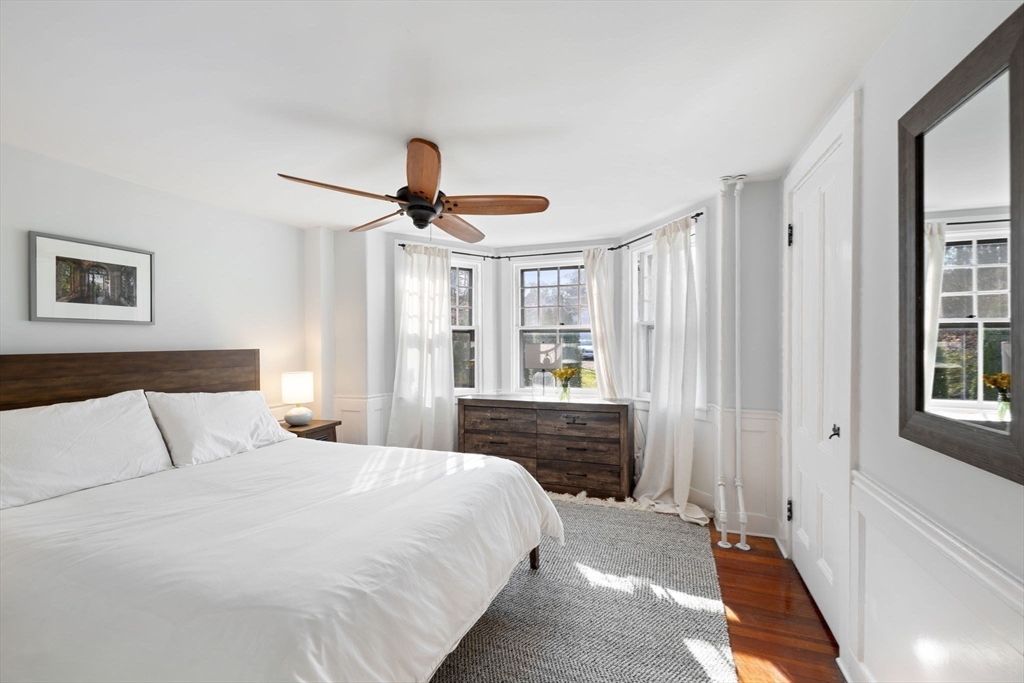 118 Main Street Sandwich, MA 02563 - Photo 14 of 41 a bedroom with a large bed and a chandelier