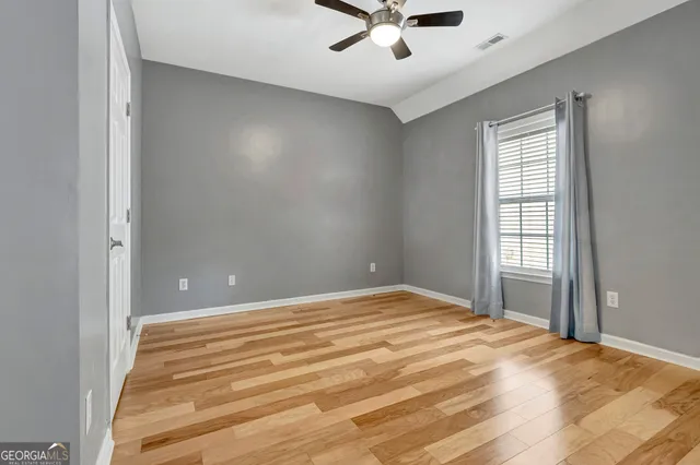 en empty room with windows and ceiling fan