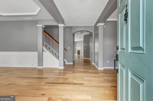 a view of empty room with wooden floor and fan