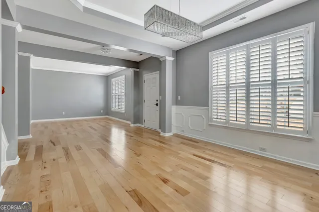 a large kitchen with kitchen island white cabinets and a chandelier