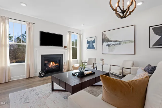 a living room with furniture a flat screen tv and a fireplace