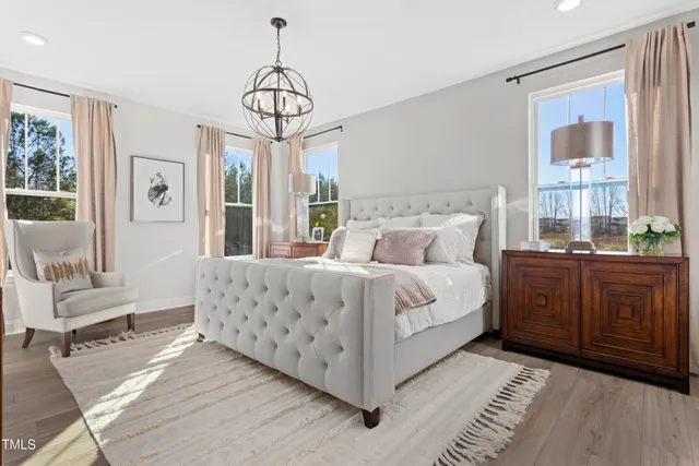 a bedroom with a large bed and a chandelier