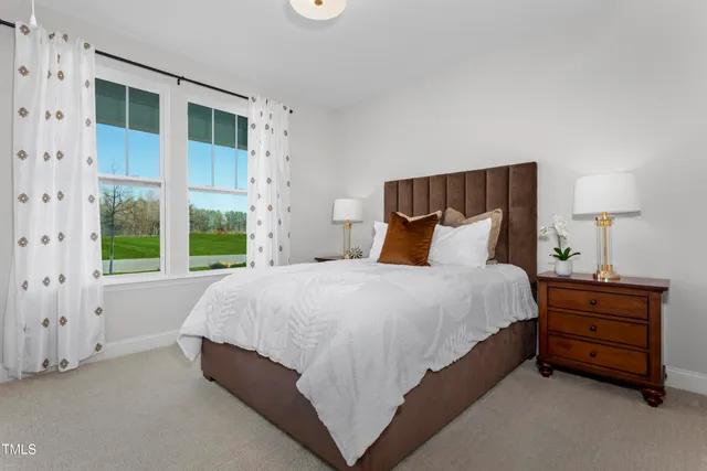 a bed sitting in a bedroom next to a window