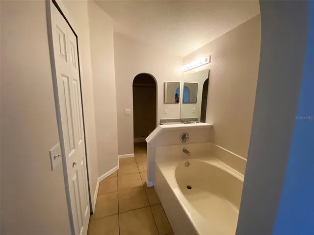 a bathroom with a tub shower and sink