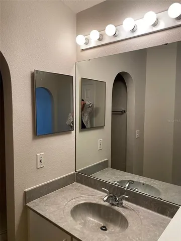 a bathroom with a granite countertop sink and a mirror
