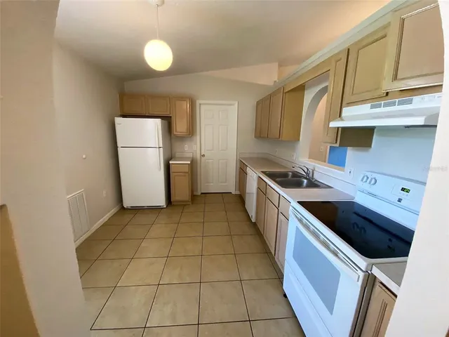 a kitchen with a stove top oven and cabinets