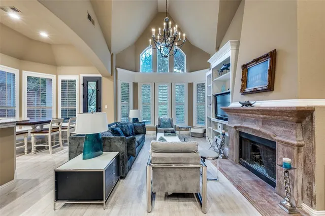 a living room with furniture a fireplace and a chandelier