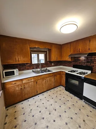 a kitchen with granite countertop a sink and a stove top oven