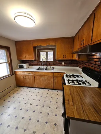 a kitchen with kitchen island a sink stove and refrigerator
