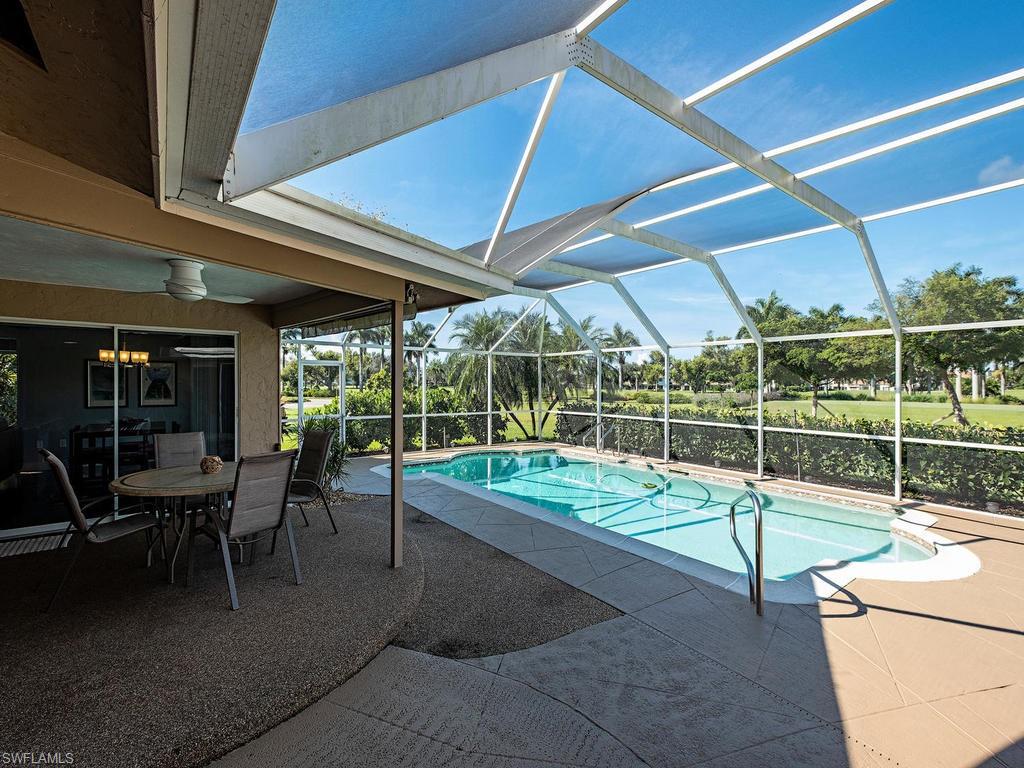 478 Torrey Pines Point Naples, FL 34113 - Photo 14 of 16 a view of a patio with table and chairs under an umbrella