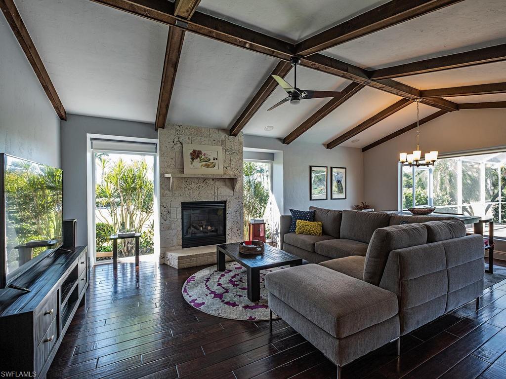 478 Torrey Pines Point Naples, FL 34113 - Photo 2 of 16 a living room with furniture a fireplace and a floor to ceiling window