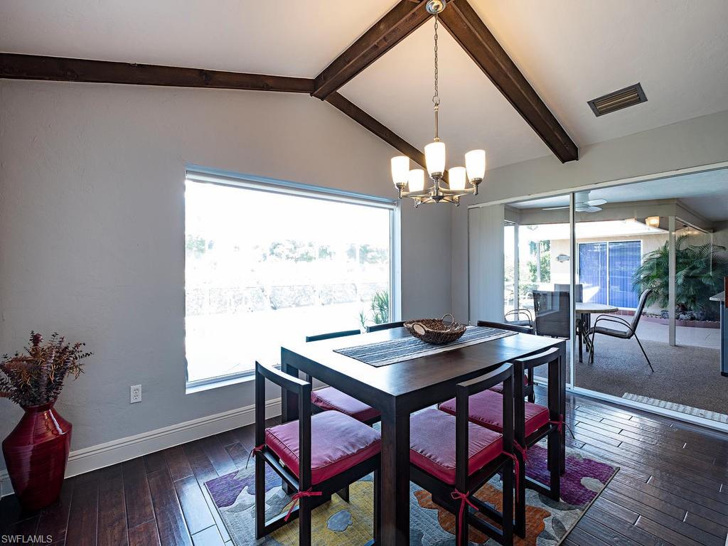 478 Torrey Pines Point Naples, FL 34113 - Photo 5 of 16 a view of a dining room with furniture wooden floor and chandelier