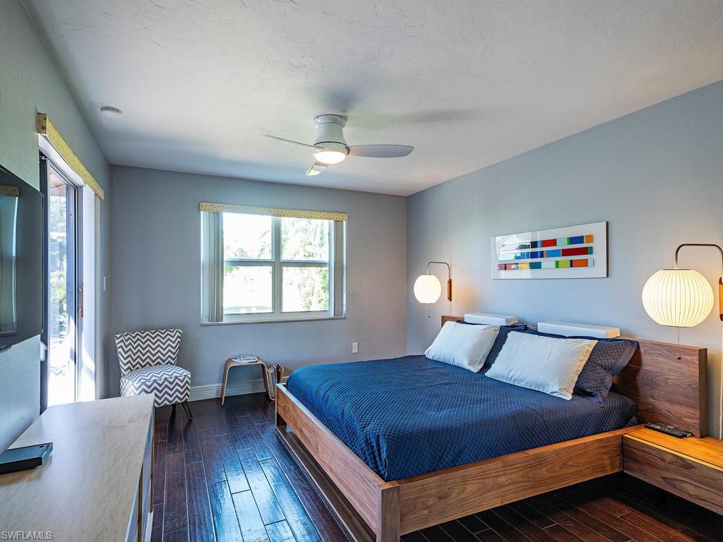 478 Torrey Pines Point Naples, FL 34113 - Photo 7 of 16 a bedroom with a large bed and a chandelier