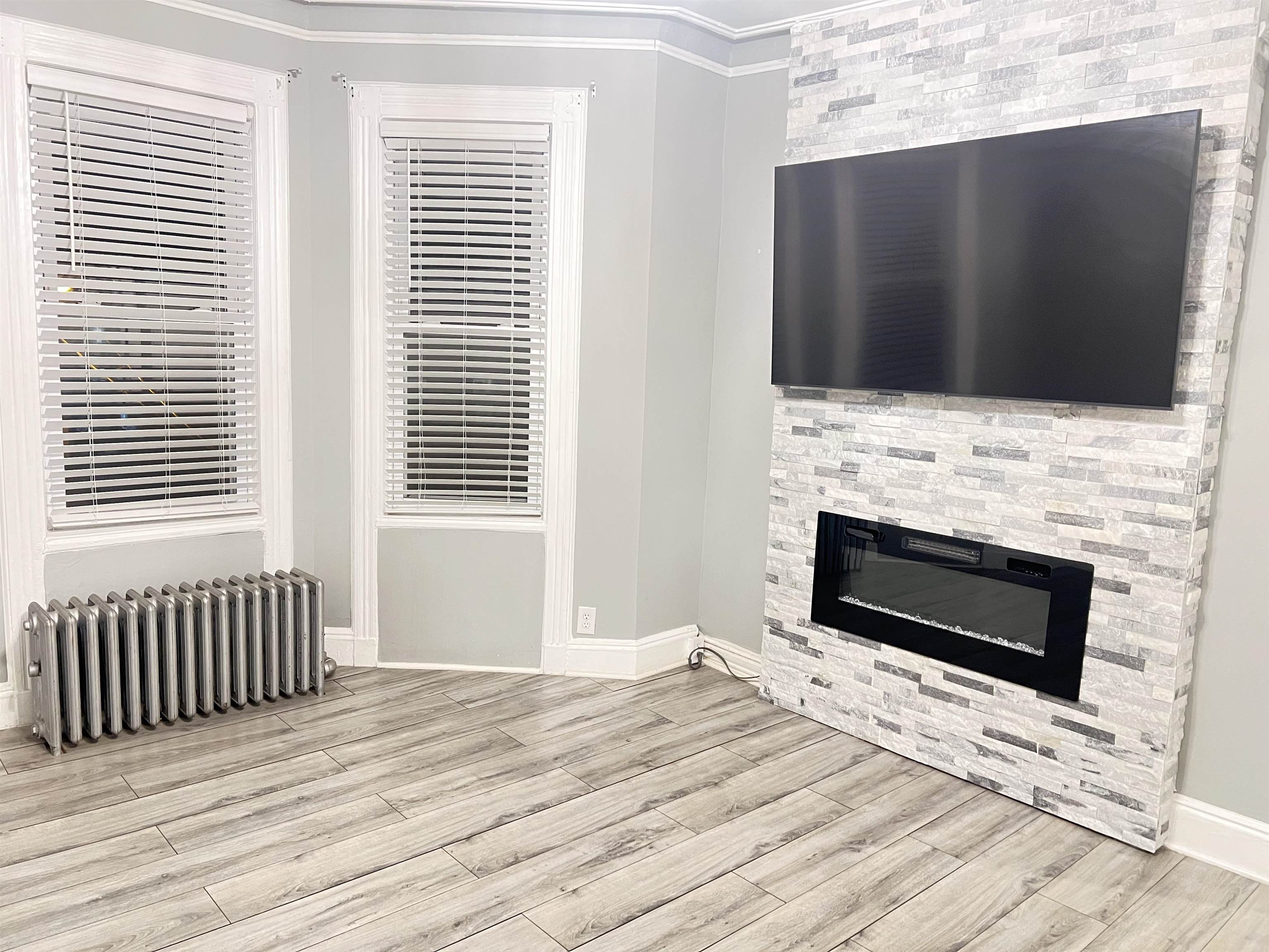 6126 Washington Street, Unit 2 West New York, NJ 07093 - Photo 2 of 7 a bedroom with fireplace and wooden floor