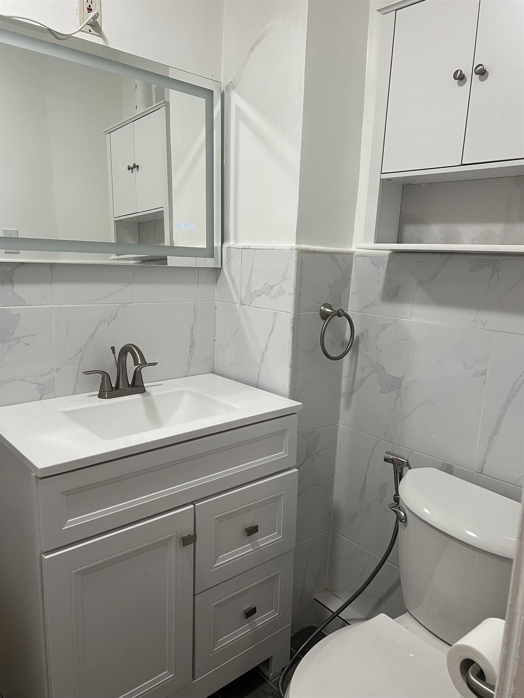 6126 Washington Street, Unit 2 West New York, NJ 07093 - Photo 4 of 7 a bathroom with a toilet sink and mirror