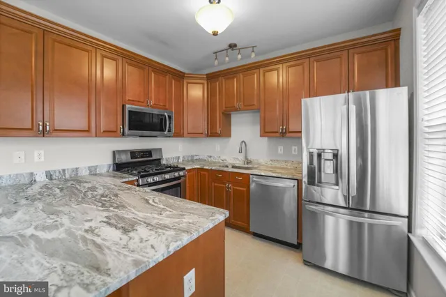 a kitchen with stainless steel appliances granite countertop a refrigerator stove microwave and sink