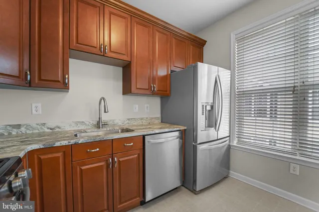 a kitchen with stainless steel appliances granite countertop a refrigerator and a sink