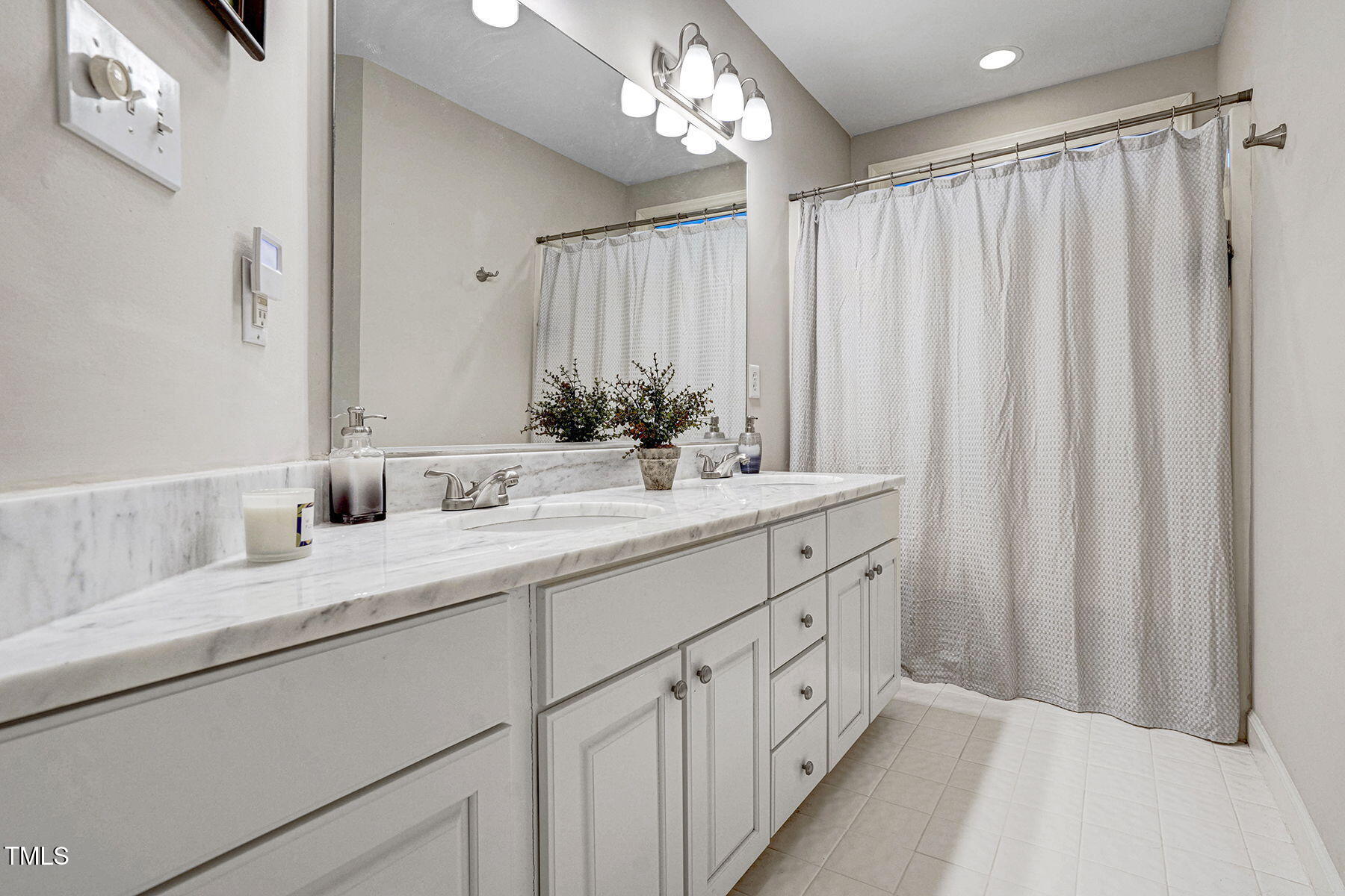 113 Waterfall Court Cary, NC 27513 - Photo 24 of 30 a bathroom with a double vanity sink and a mirror