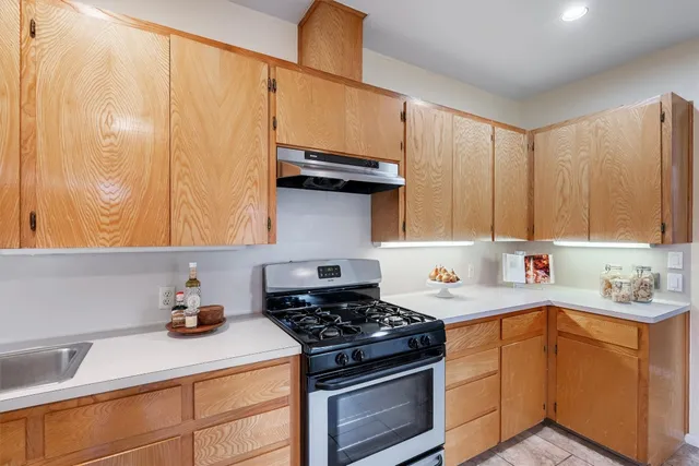 a kitchen with stainless steel appliances a sink a stove and cabinets