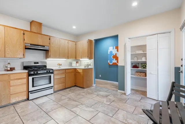 a kitchen with stainless steel appliances granite countertop a stove a sink and a refrigerator