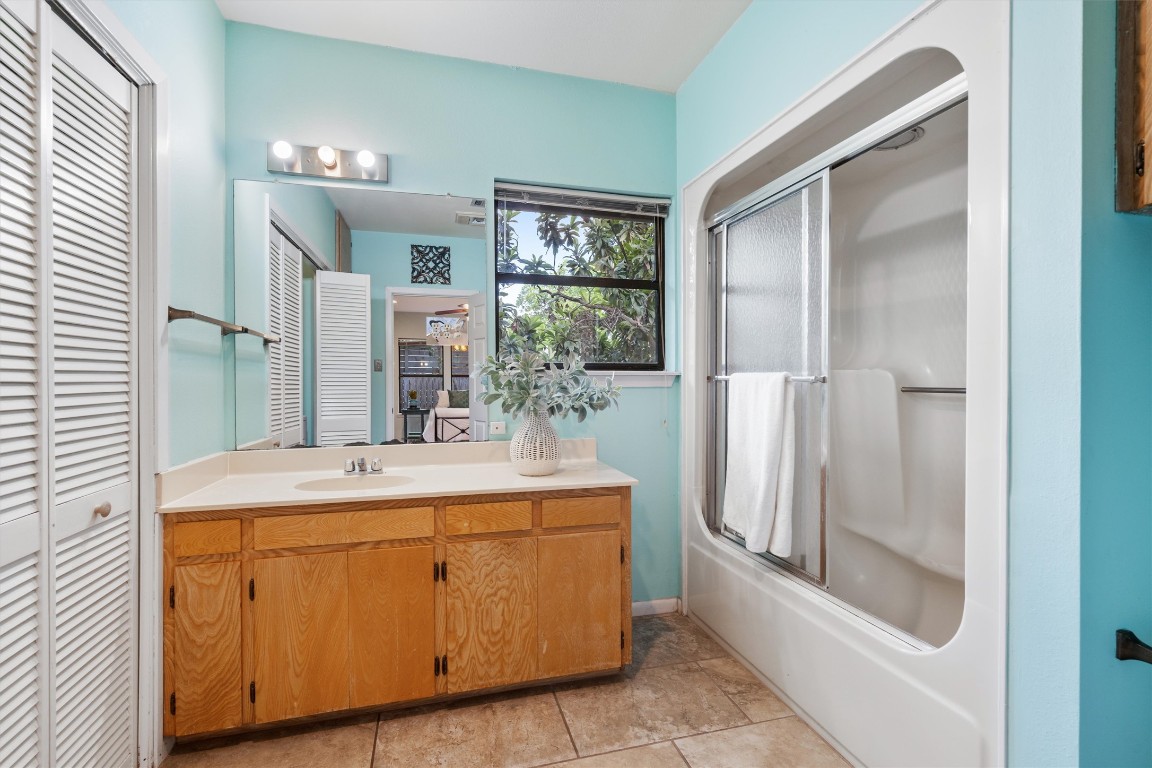 2116 Glendale Place Austin, TX 78704 - Photo 16 of 24 a bathroom with a granite countertop sink a mirror and a shower