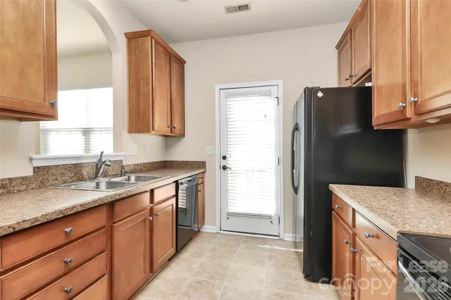 a kitchen with stainless steel appliances granite countertop a refrigerator and a sink