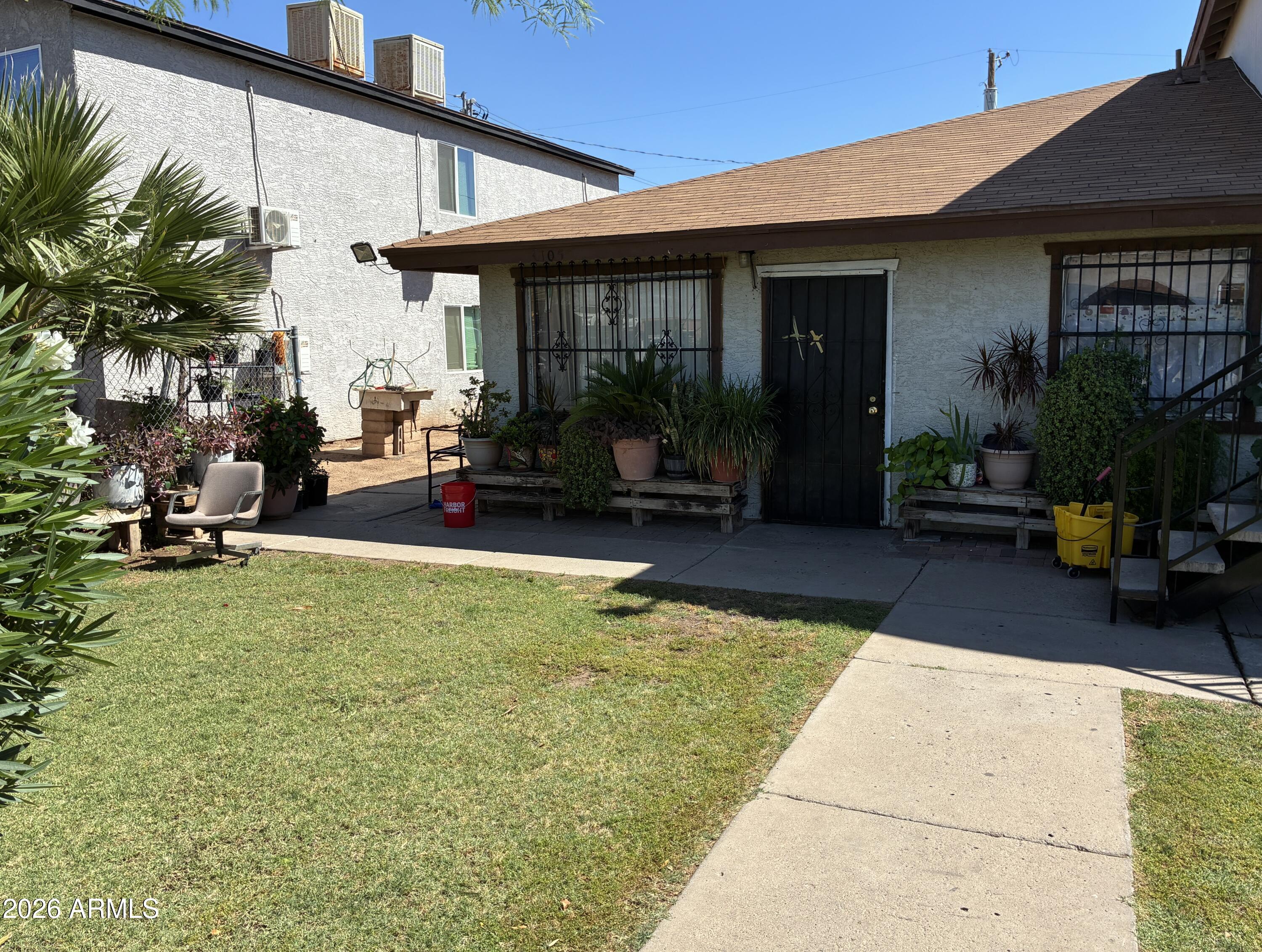 3105 West Madison Street Phoenix, AZ 85009 - Photo 4 of 8 a view of a patio with table and chairs potted plants and a large tree