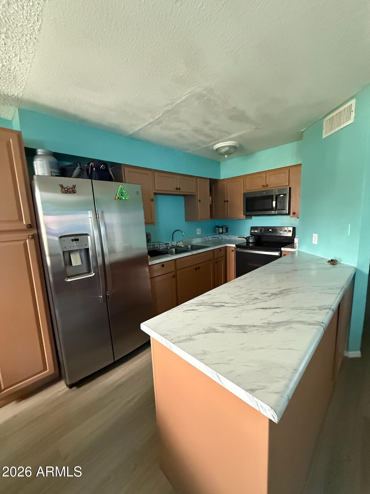 3105 West Madison Street Phoenix, AZ 85009 - Photo 6 of 8 a kitchen with stainless steel appliances a refrigerator and a counter top
