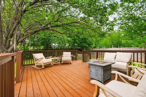 a balcony with wooden floor and outdoor seating