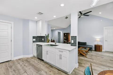 a kitchen with stainless steel appliances a sink a stove a refrigerator cabinets and a counter space