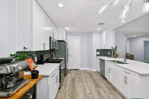 a living room with furniture a fireplace and a chandelier