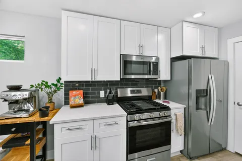 a kitchen with sink a stove and cabinets