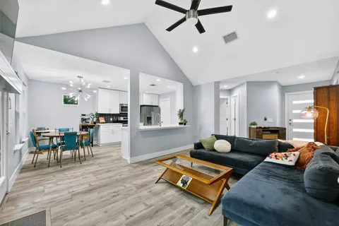 a living room with furniture and a wooden floor