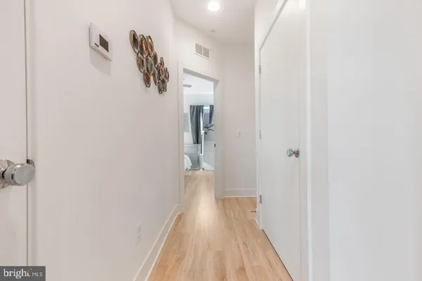 a view of a hallway with wooden floor and closet
