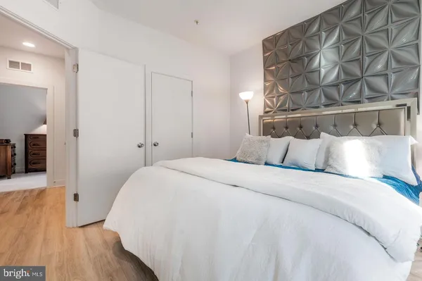 a bedroom with a bed and a wooden floor